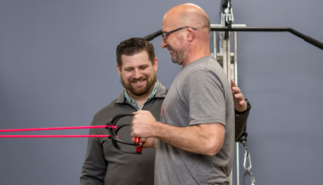 Drew assisting a patient with resistance training exercise